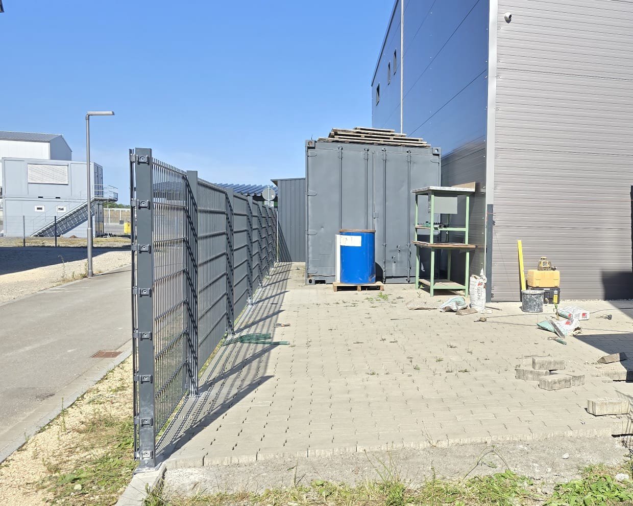 Zaunpfosten in Flucht an einer Gewerbehalle