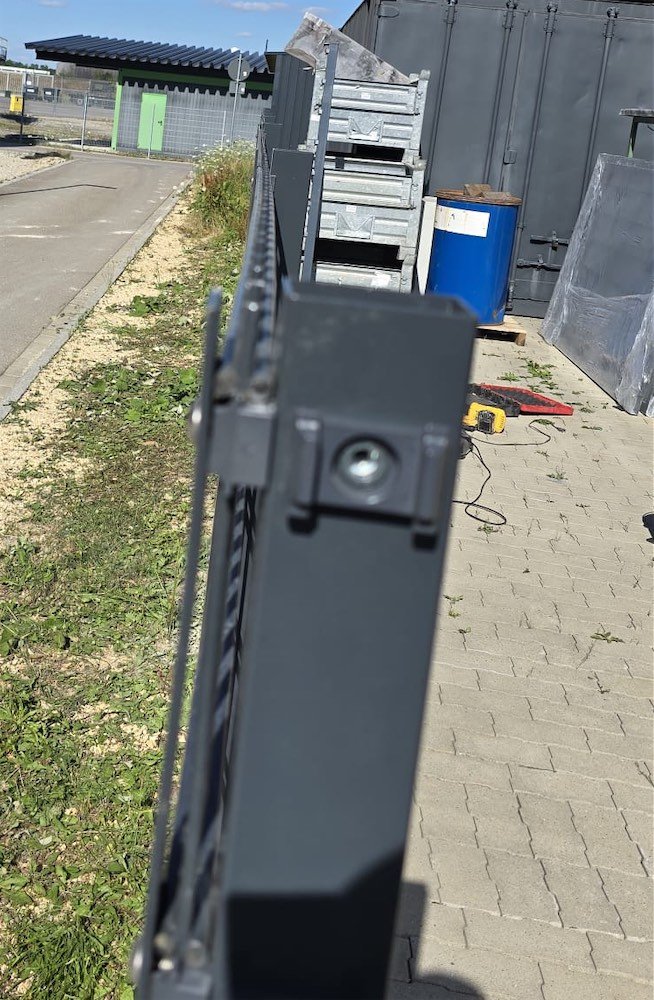 Nahaufnahme eines anthrazitfarbenen Zaunpfostens mit Abdeckleiste